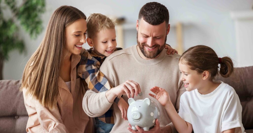 Familie spart und wirft eine Münze in ein Sparschwein